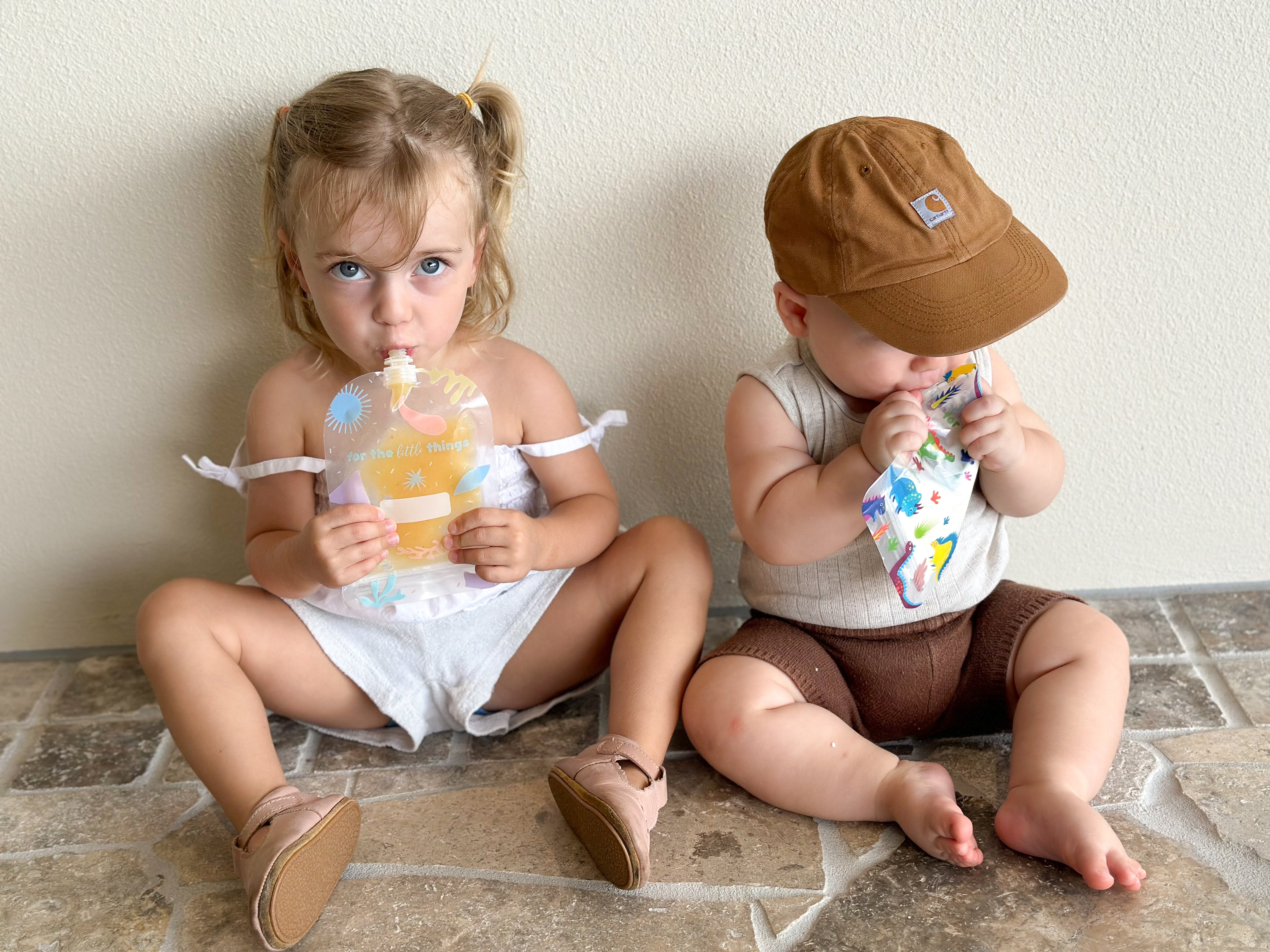 Toddler and baby eating from Sinchies reusable food pouches