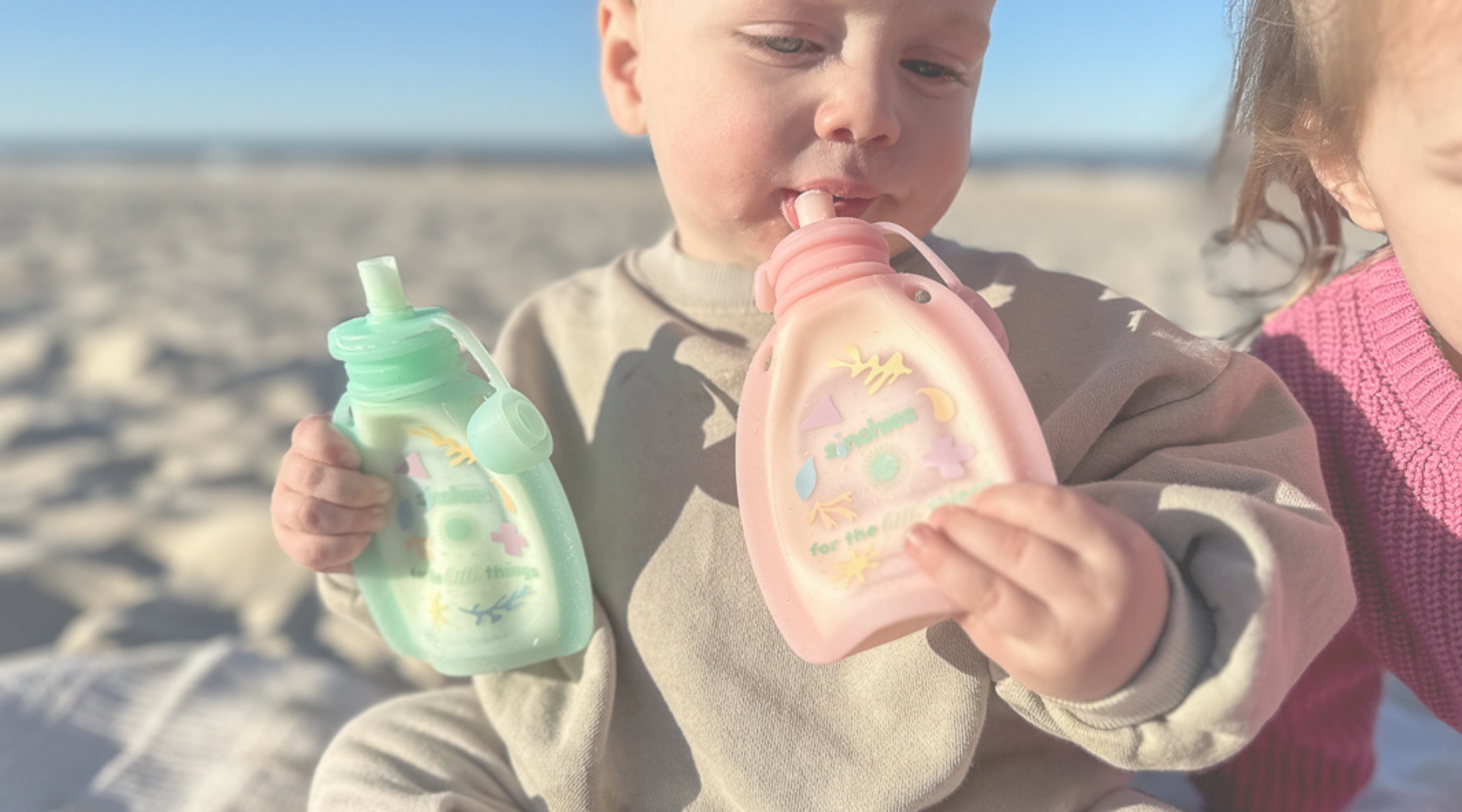 baby drinking yoghurt from reusable food pouch