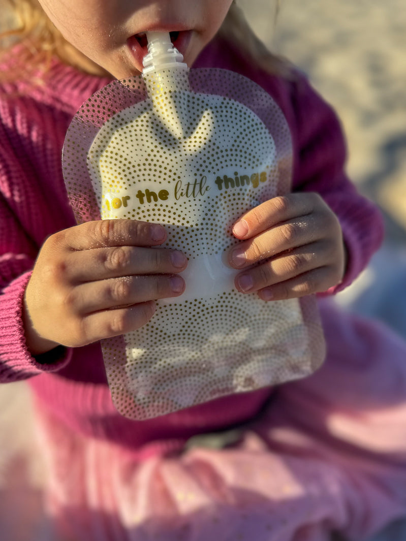 Girl drinking from yoghurt pouch