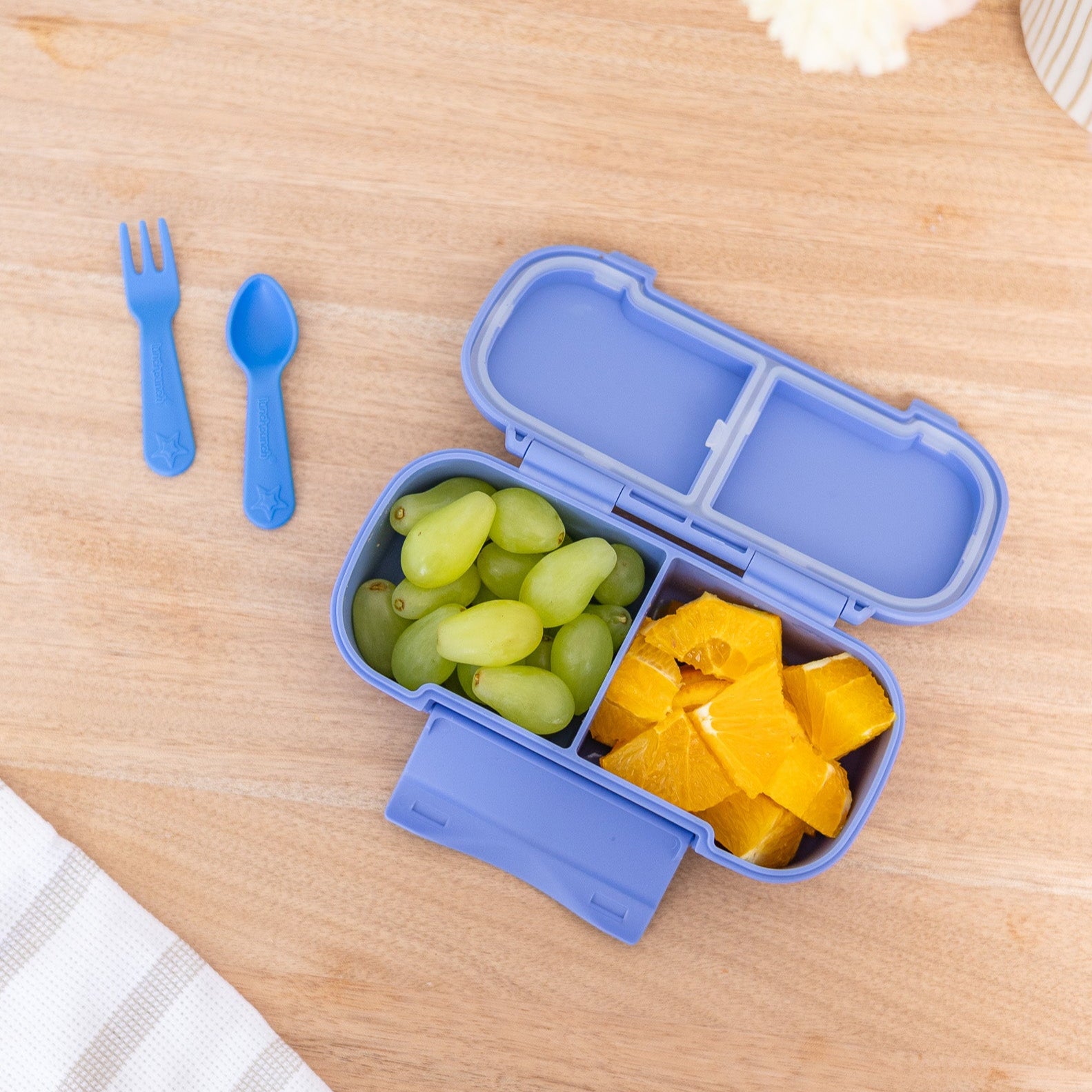 Blue bento box with fruits on a wooden table