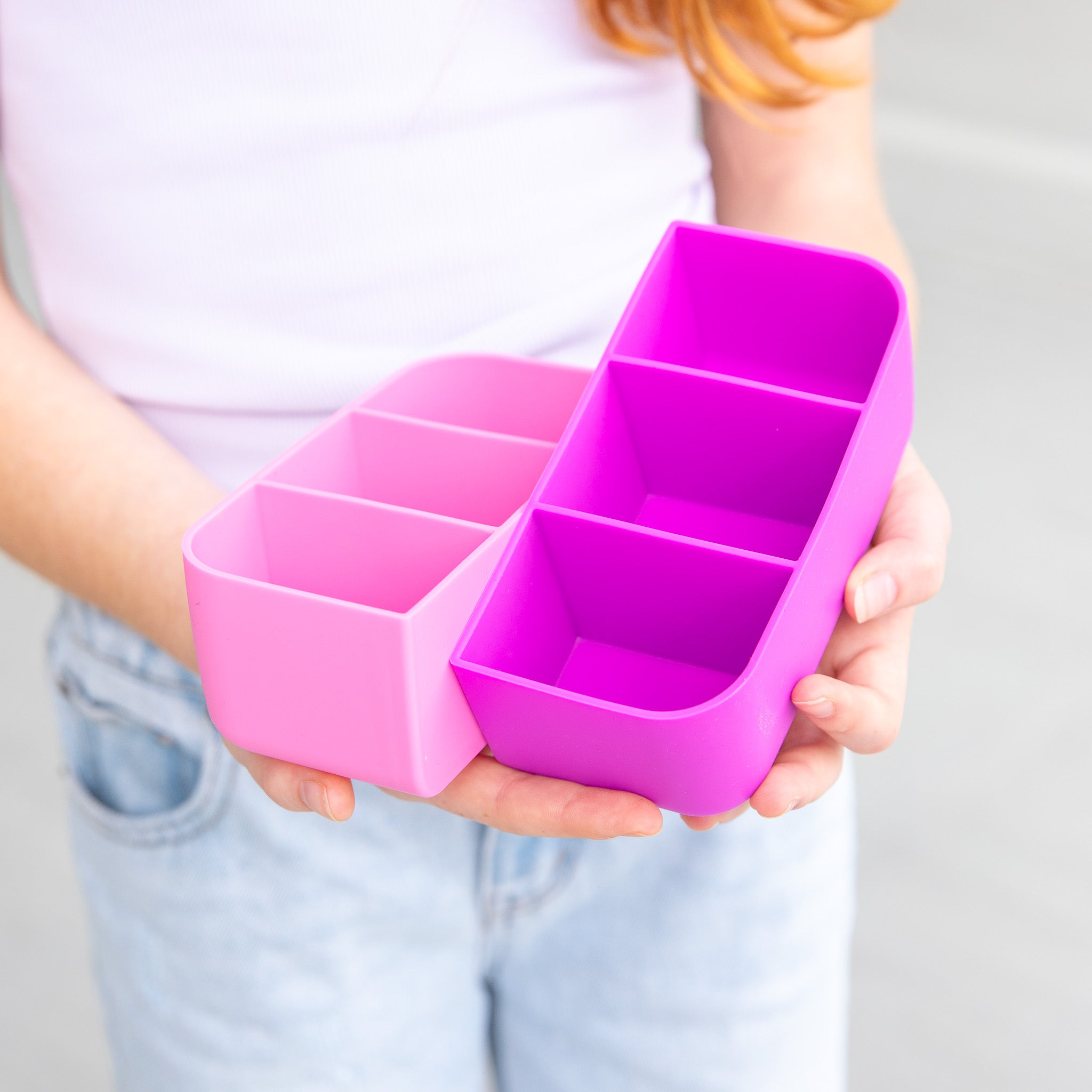 Person holding a pink and purple divided container