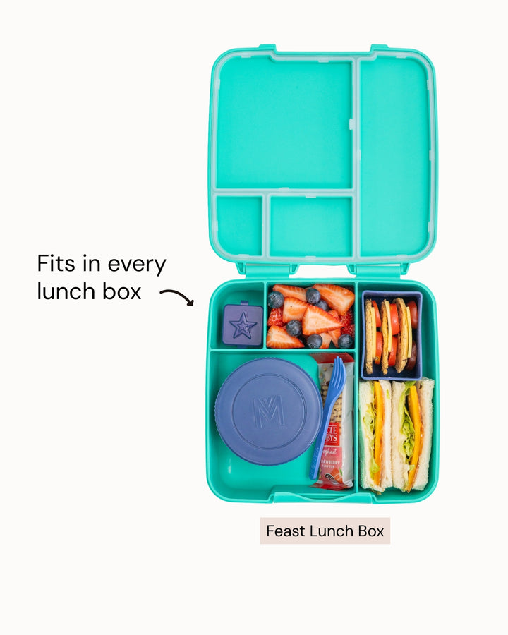 Turquoise lunch box with compartments filled with snacks and a purple lid, on a white background.