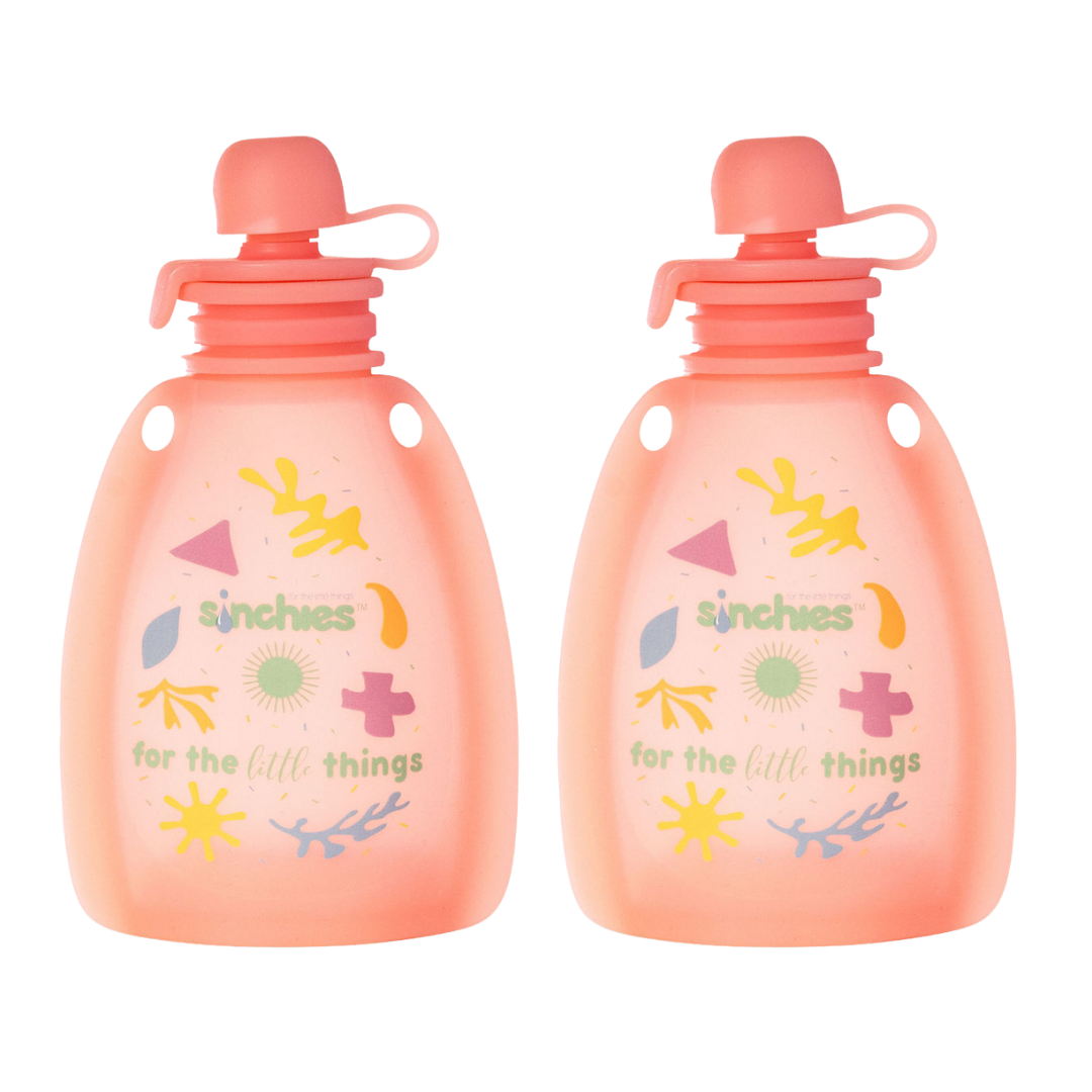 Two pink yoghurt pouches with colorful designs and text on a white background