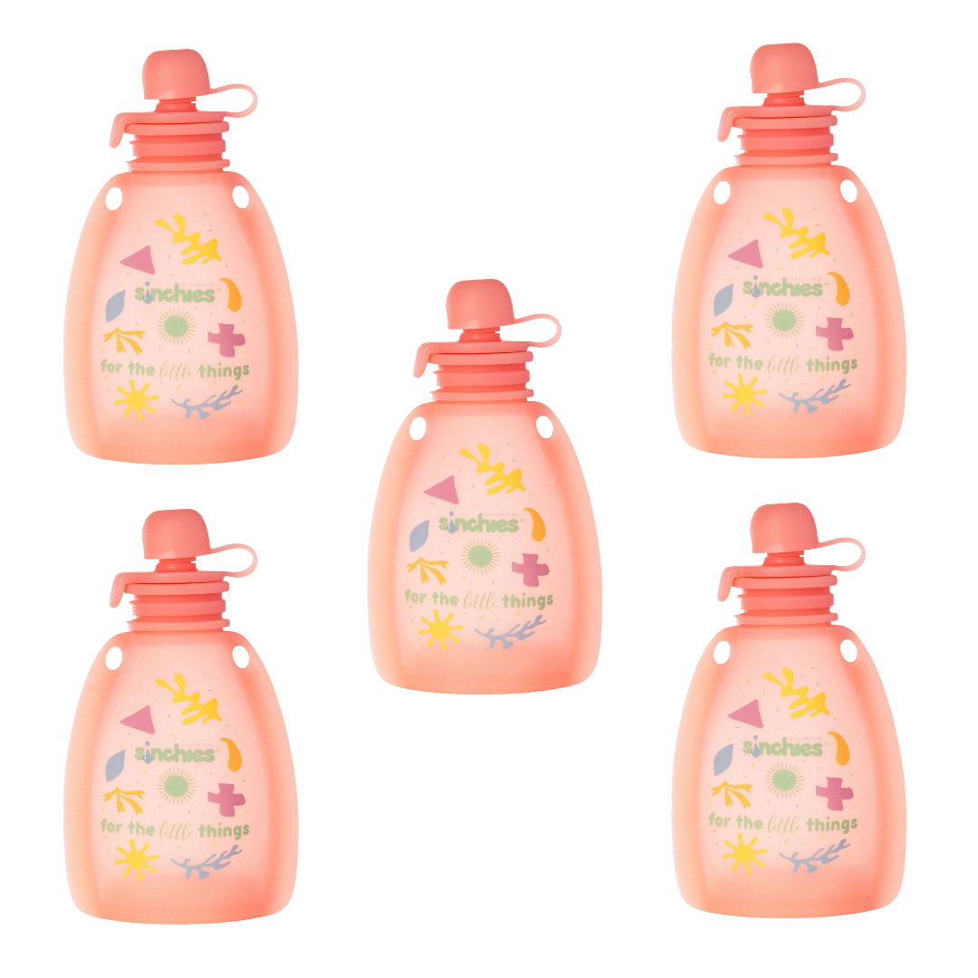 Five pink yoghurt pouches with colorful designs and text on a white background