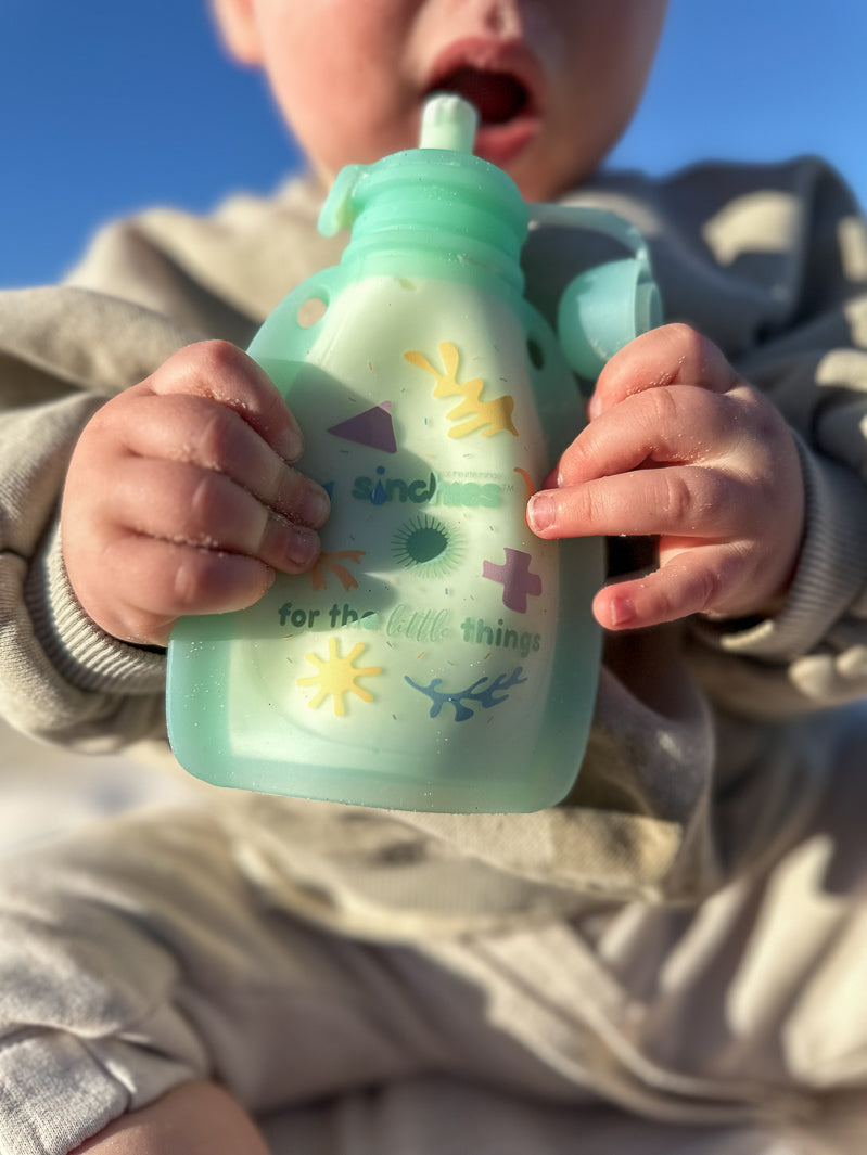 Baby eating yoghurt in silicone squeezy pouch